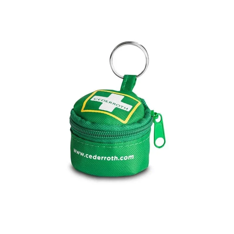 Die Cederroth Atemmaske im Schlüsselanhänger von Orkla Wound Care AB ist ein kleiner grüner Reißverschlussbeutel mit einem weißen Kreuz, dem Schriftzug "Cederroth", einem Schlüsselring und www.cederroth.com an der Seite. Enthält 1 Stück Erste Hilfe Atemmaske.