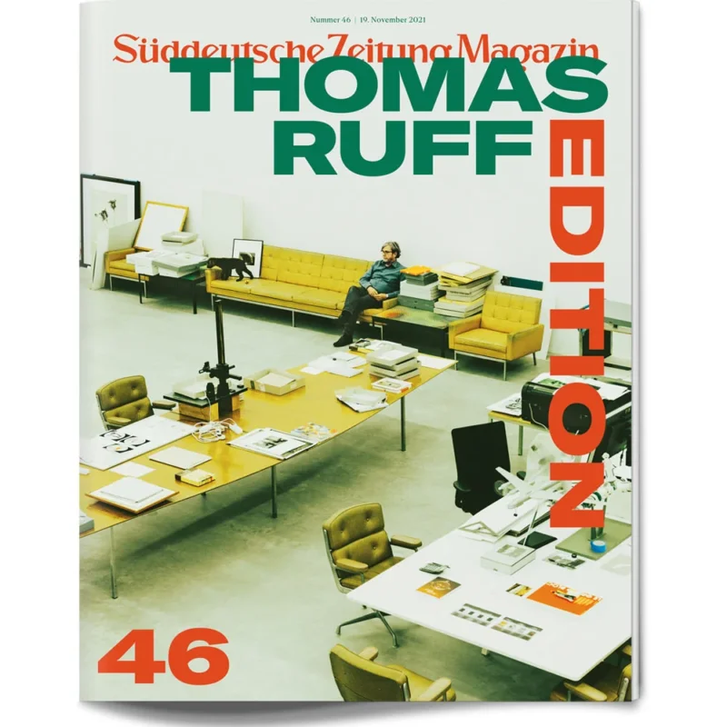 Das Titelbild zeigt einen Mann, der auf einem gelben Sofa in einem modernen Studio sitzt, umgeben von Tischen, Kunst und Büchern.